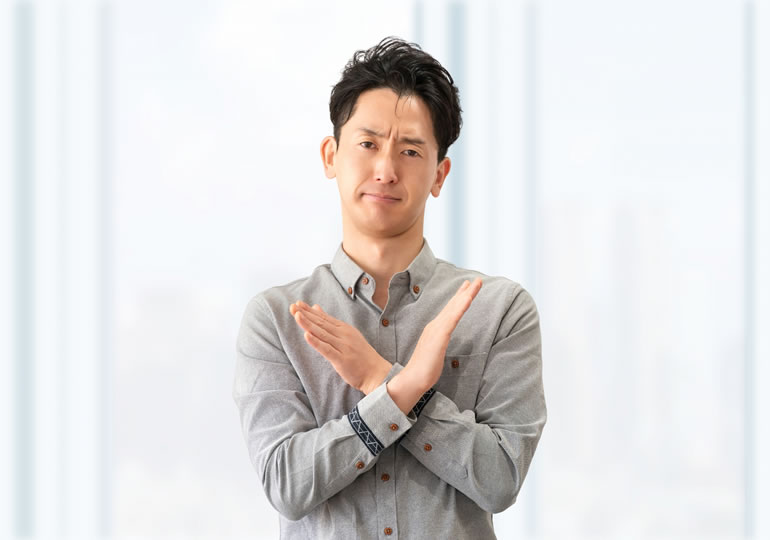 腕をクロスしてバツを作って散骨の禁止条例を説明する自治体の男性