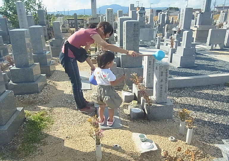 お墓参りをする母と子供
