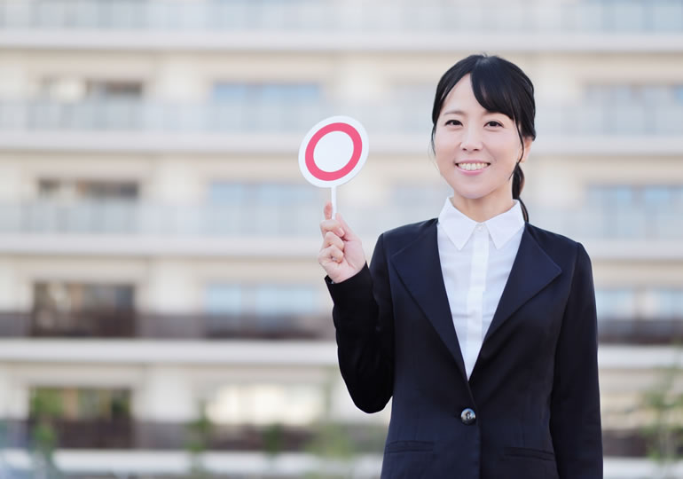 散骨は違法ではないと丸の札を持っている女性