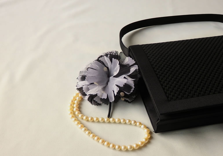 葬式用のパールネックレスと黒いハンドバック