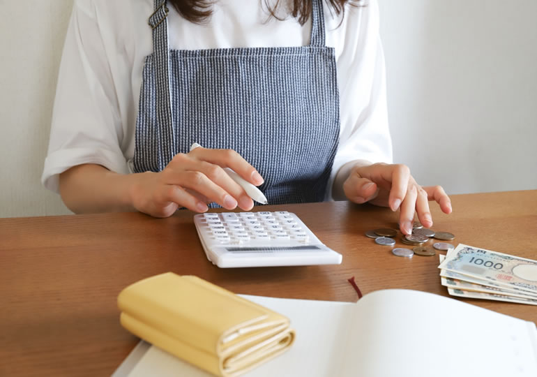 高額な葬儀費用の計算をする主婦