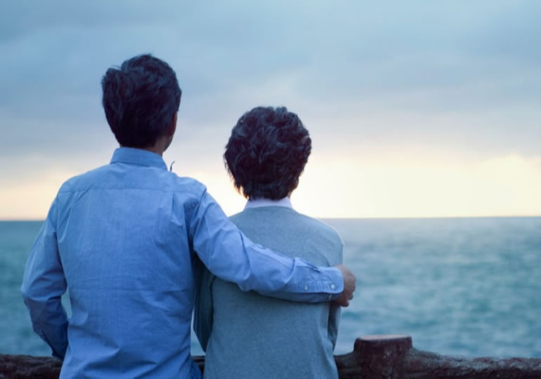 肩を組み水平線を見つめる老夫婦