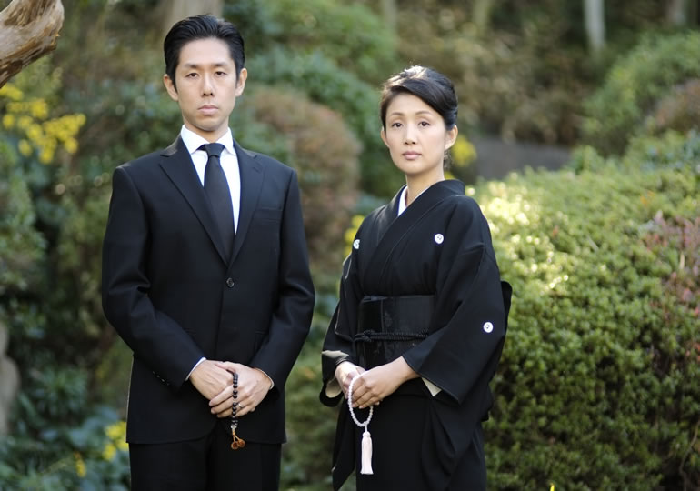 喪服を着て立っている家族