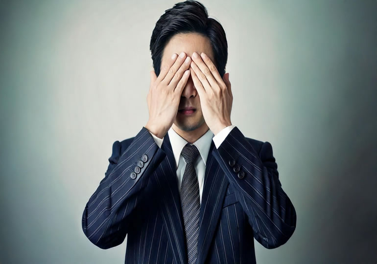 両手を目に当てなのも見えないジェスチャーをする男性