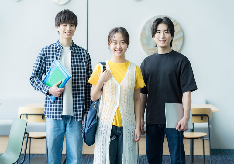 笑顔でこちらを向くz世代の大学生3人