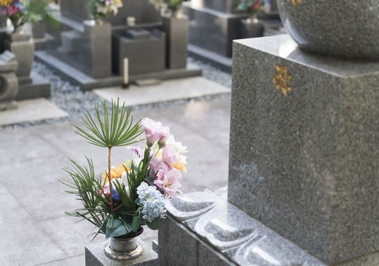 お墓参りに造花を持って行く親子