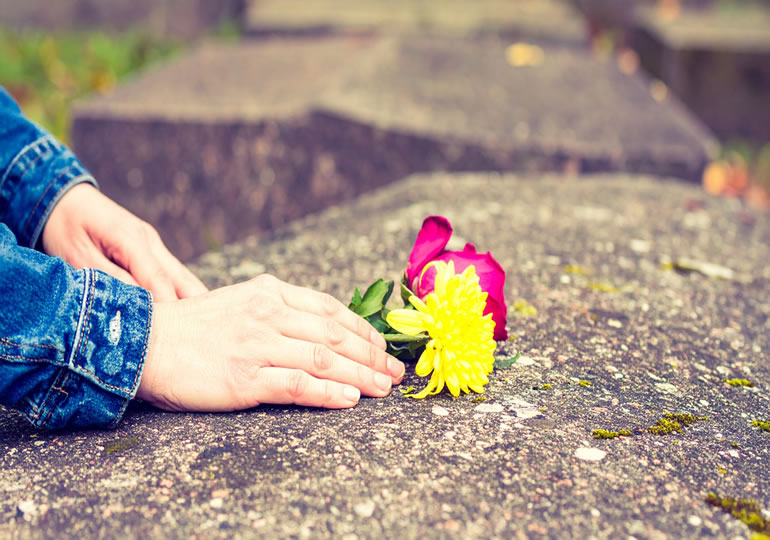 お墓に献花する女性の手元