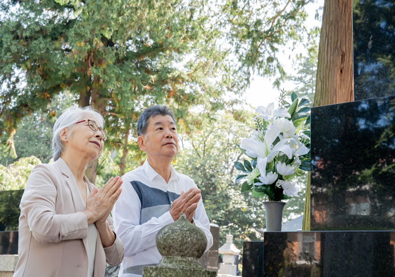 墓参りをする高齢夫婦