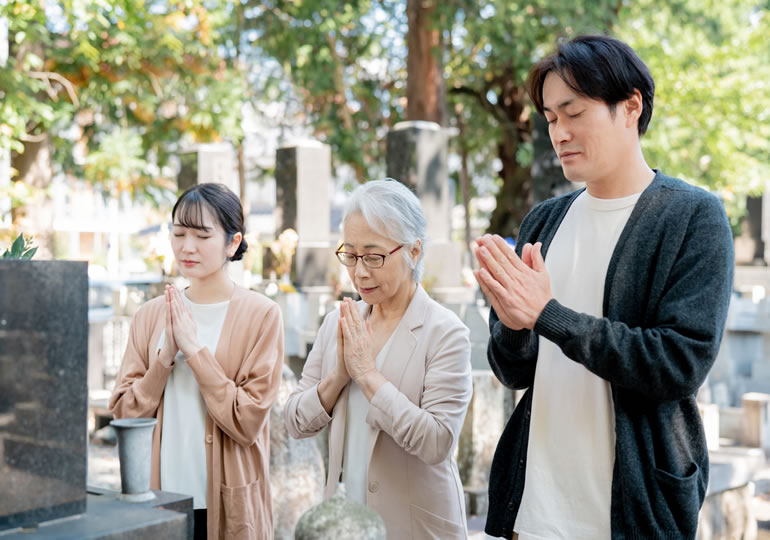 父親の墓参りをする家族
