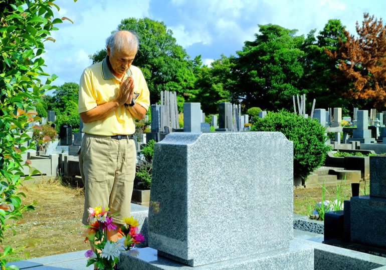 墓参りをするお一人様の高齢男性