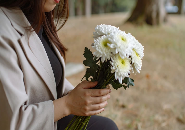 菊の花を持つ女性の手元