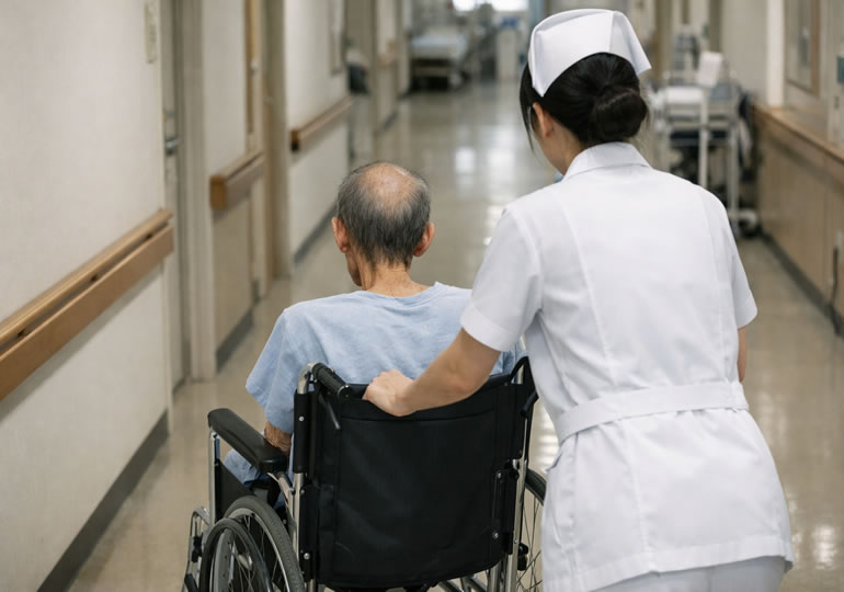 高齢者の車椅子を押している看護師