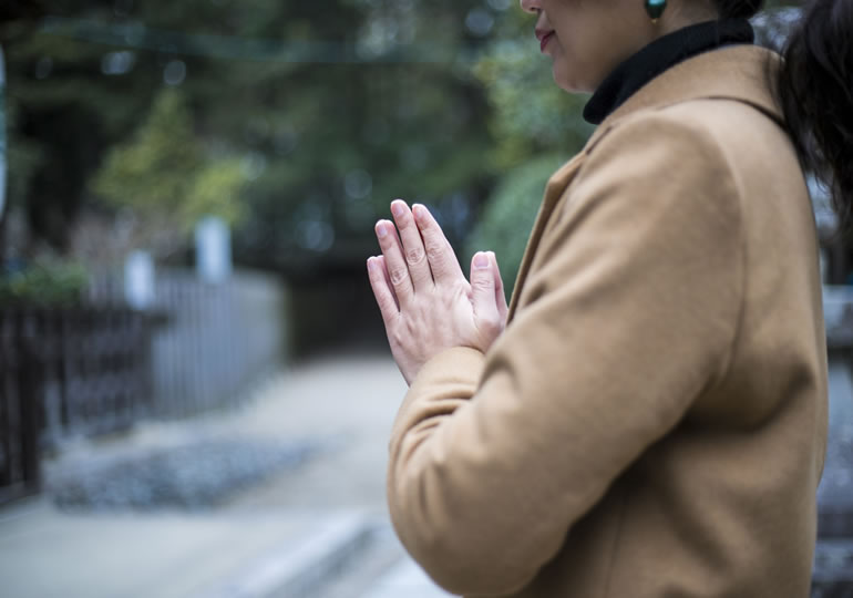 先祖供養のため合掌する女性