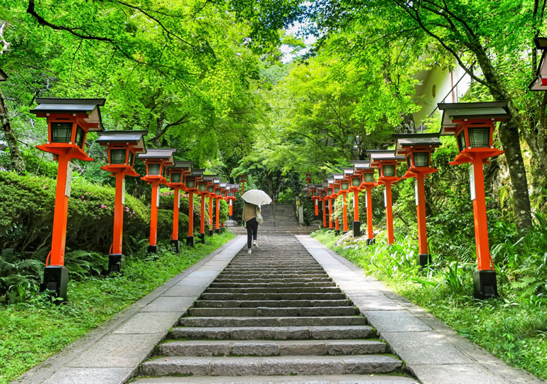 神社の階段を参拝の為に上る女性