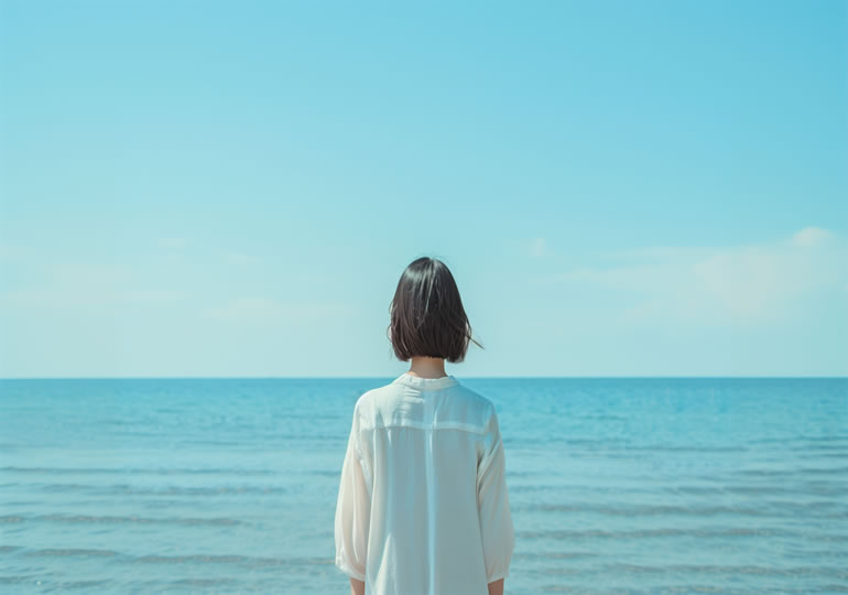海洋散骨をした後に海を見つめる女性の後ろ姿