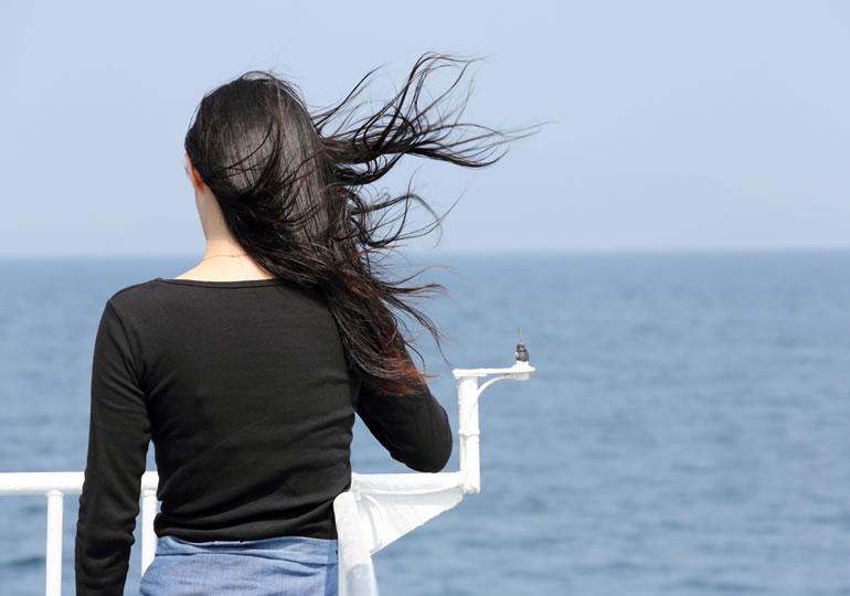 散骨をして海を眺める女性の後ろ姿