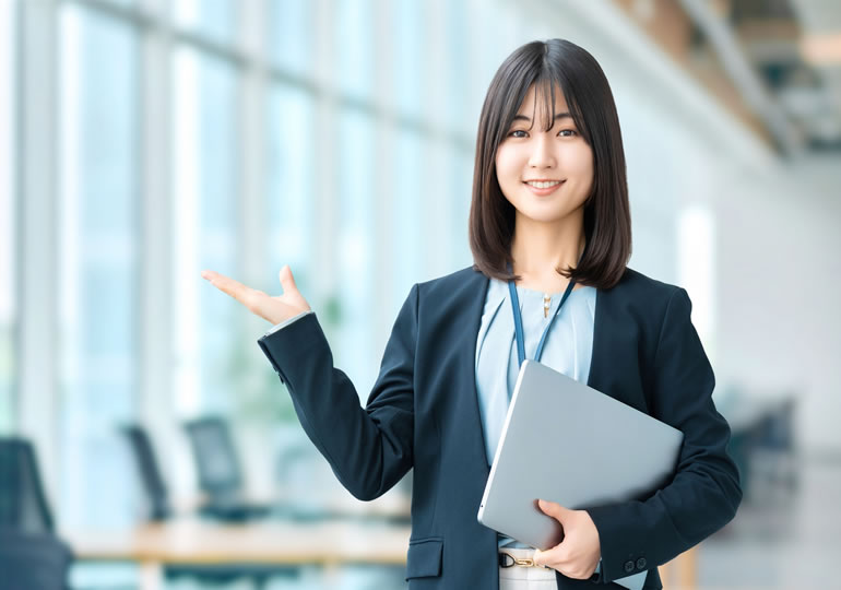 スーツ姿で社内を案内をする女性