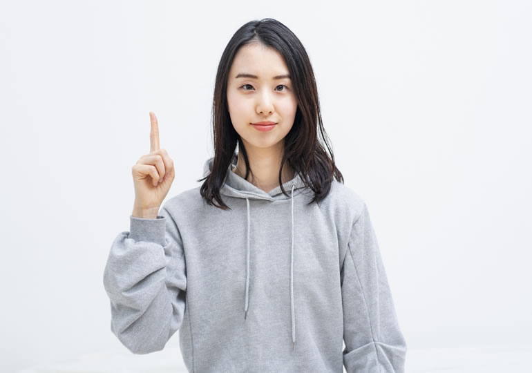 人差し指を立てて、散骨業者の選び方を解説する女性