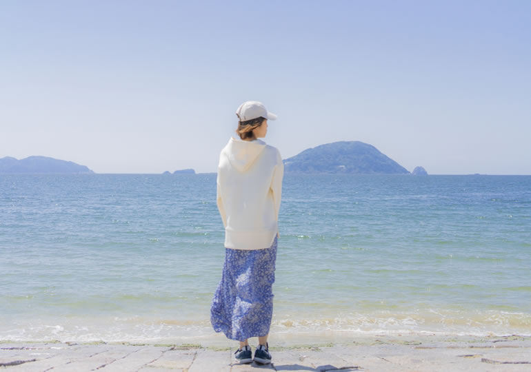散骨した水平線の海を見つめる女性