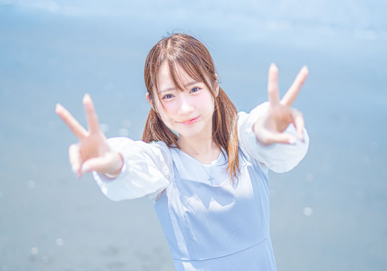 浜辺でピースサインをするz世代の女性