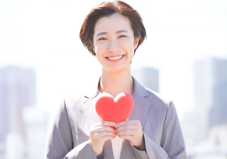 胸の前でハートマークを持つ女性