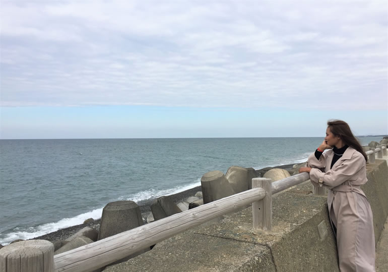散骨した海を防波堤から見つめる女性