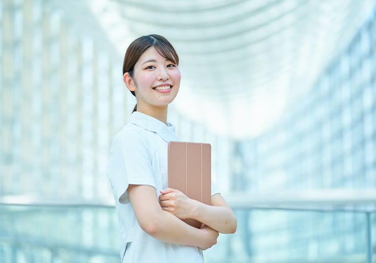 高齢者施設で働く白衣の女性スタッフ