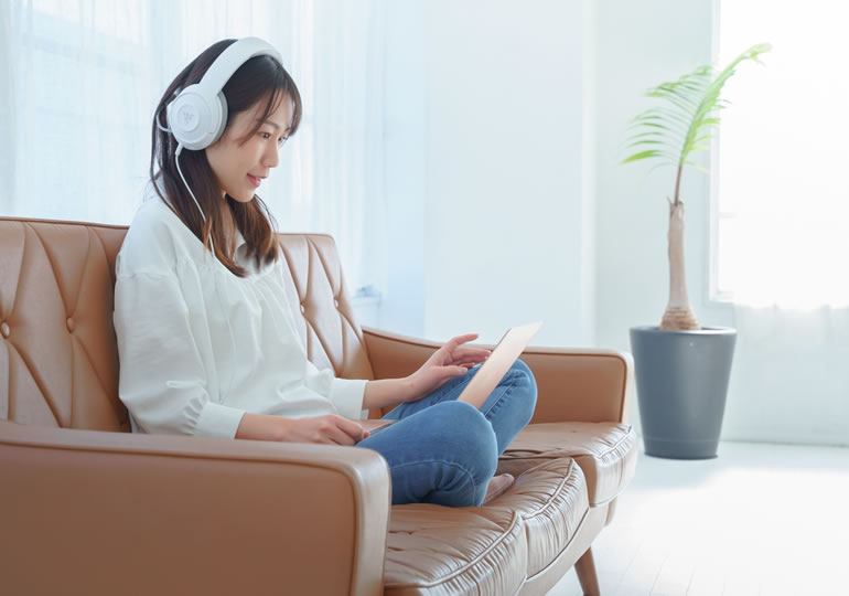 ソファーで寛ぎながら終活動画を見る女性