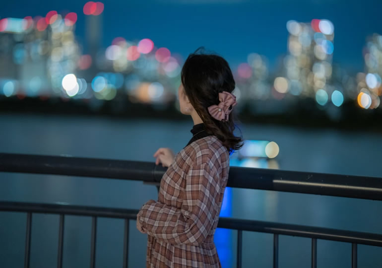 船から東京の夜景を眺める女性