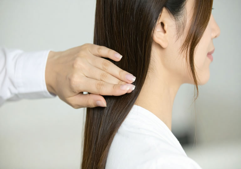 美容室で髪をカットする女性