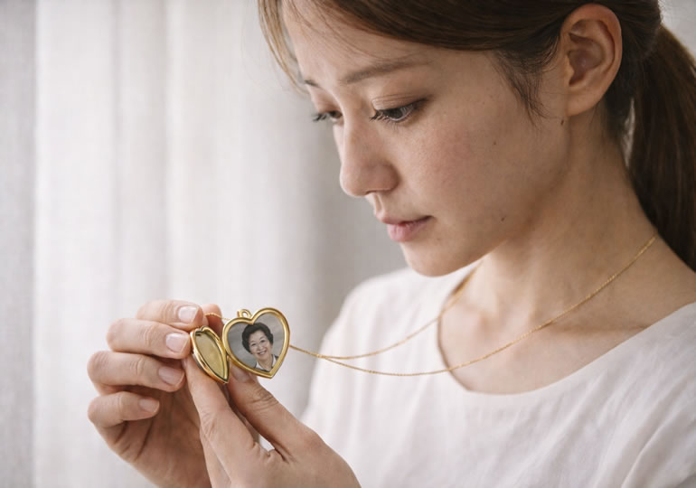 ペンダントの写真を見る若い女性