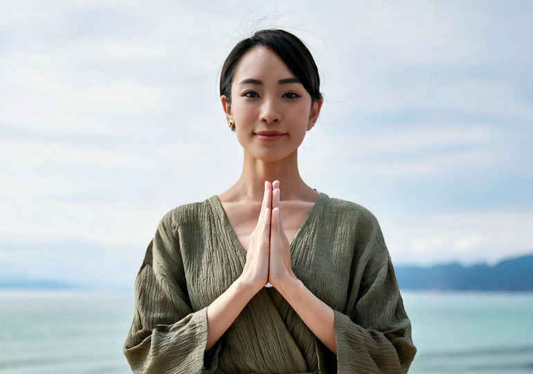 清々しい笑顔で手を合わせる若い女性