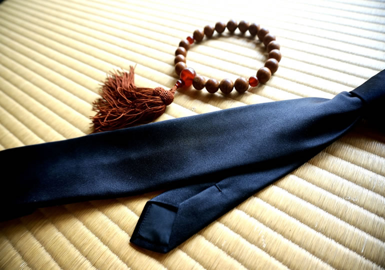 畳の上に置かれた黒ネクタイと数珠
