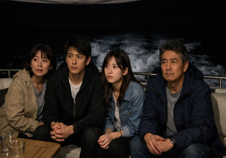 暗い静かな海を見つめる家族