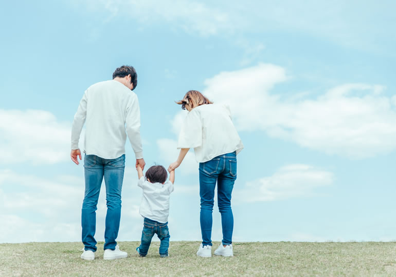 子供と手をつなぐ親子の後ろ姿
