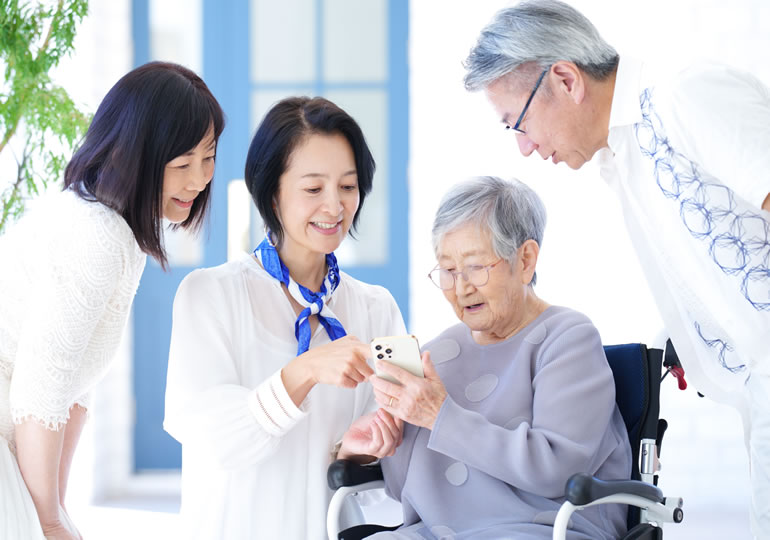 遠方で海洋散骨に参加できなかった親族が、送られてきた散骨風景をスマートフォンで確認している画像