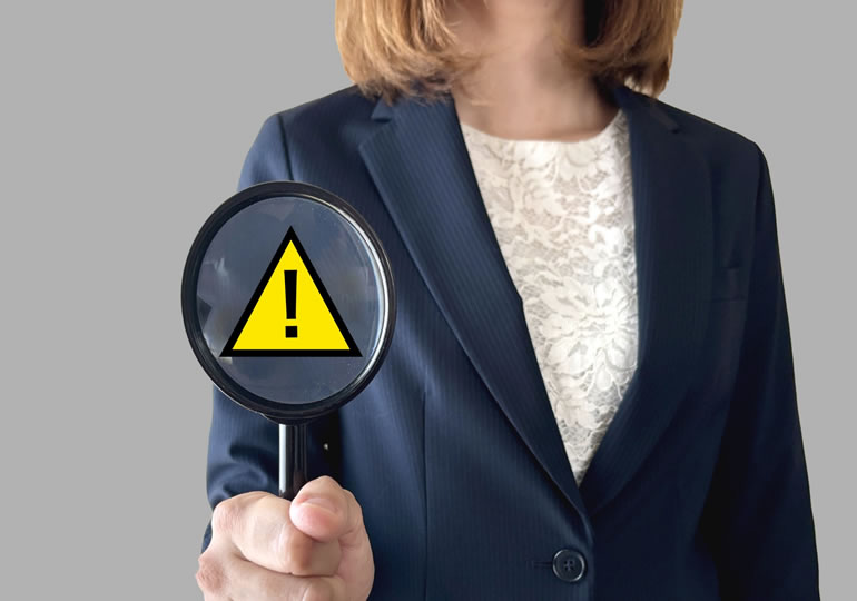 虫眼鏡を持って業者の見極めを説明する女性
