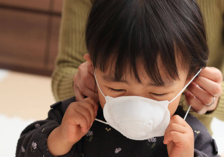 家庭作業場での粉骨の為マスクをする子供