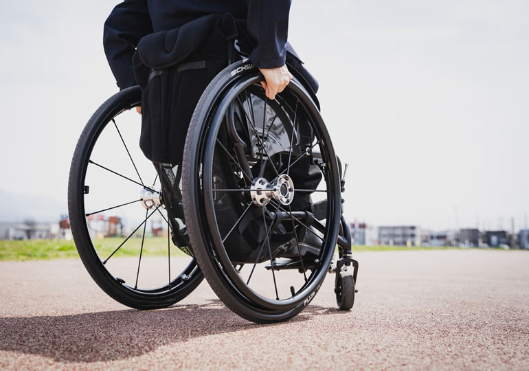 車椅子で墓参りに行く男性