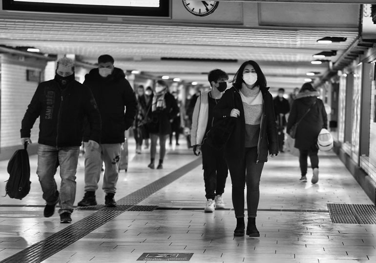 地下道をマスクをして歩く多くの外国人