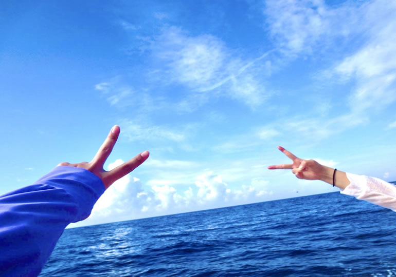 船上でピースサインをする女性二人組