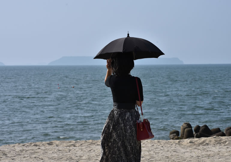 海を見つめる女性の後ろ姿