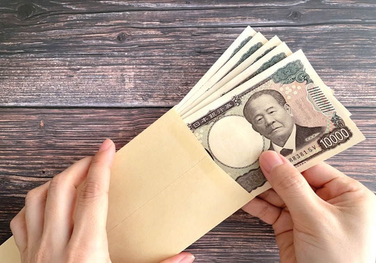 散骨費用を封筒から出す女性