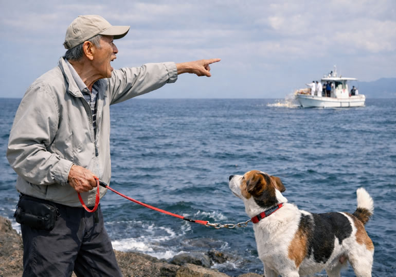 散骨している船に注意している高齢男性