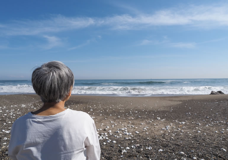 海を見つめる高齢の女性