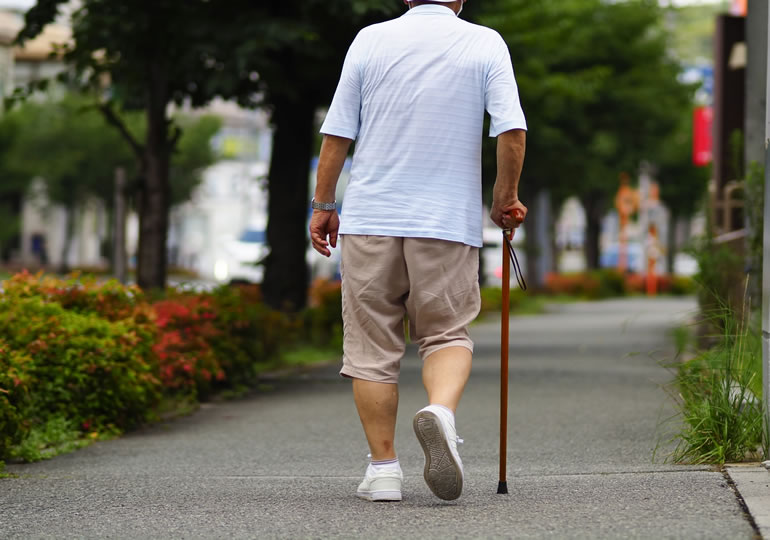 杖をついて散歩をする高齢男性の後ろ姿