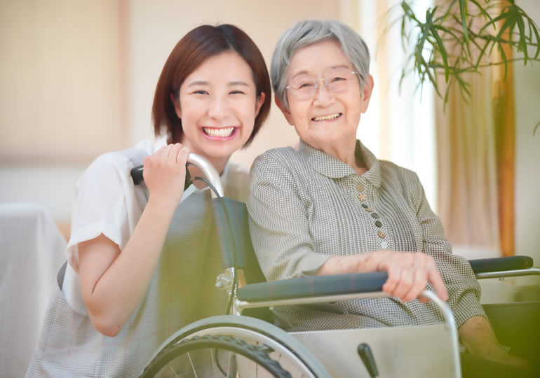 車椅子を押す娘と笑顔の母親