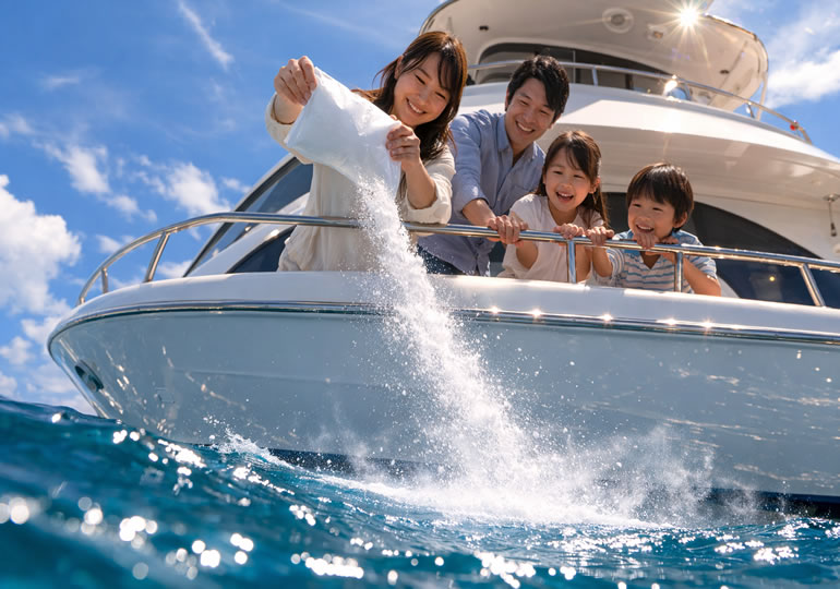 海洋散骨した海面をクルーザーからのぞき込む親族