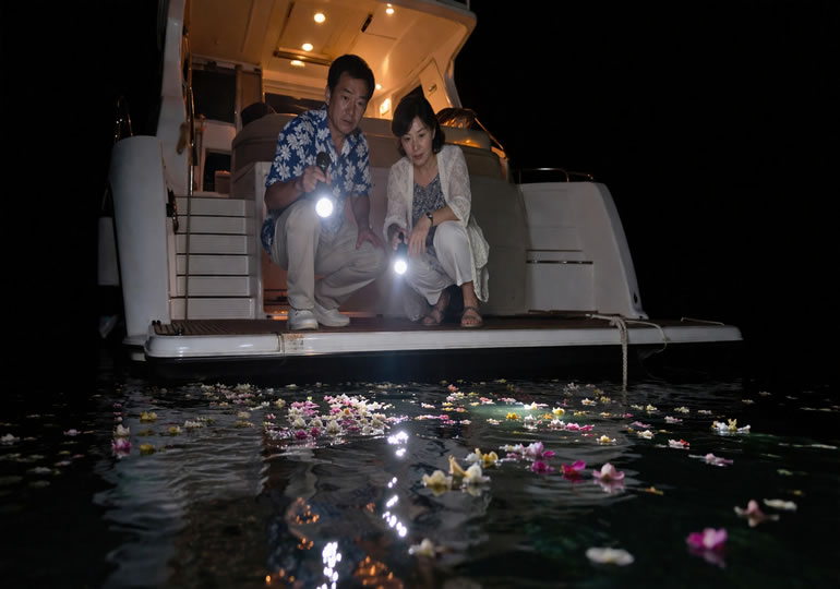 暗い海で散骨している風景