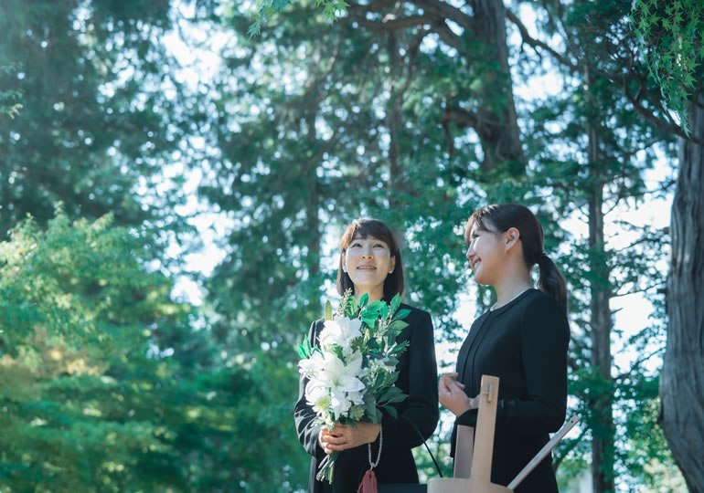 火葬場で笑顔で会話する姉妹